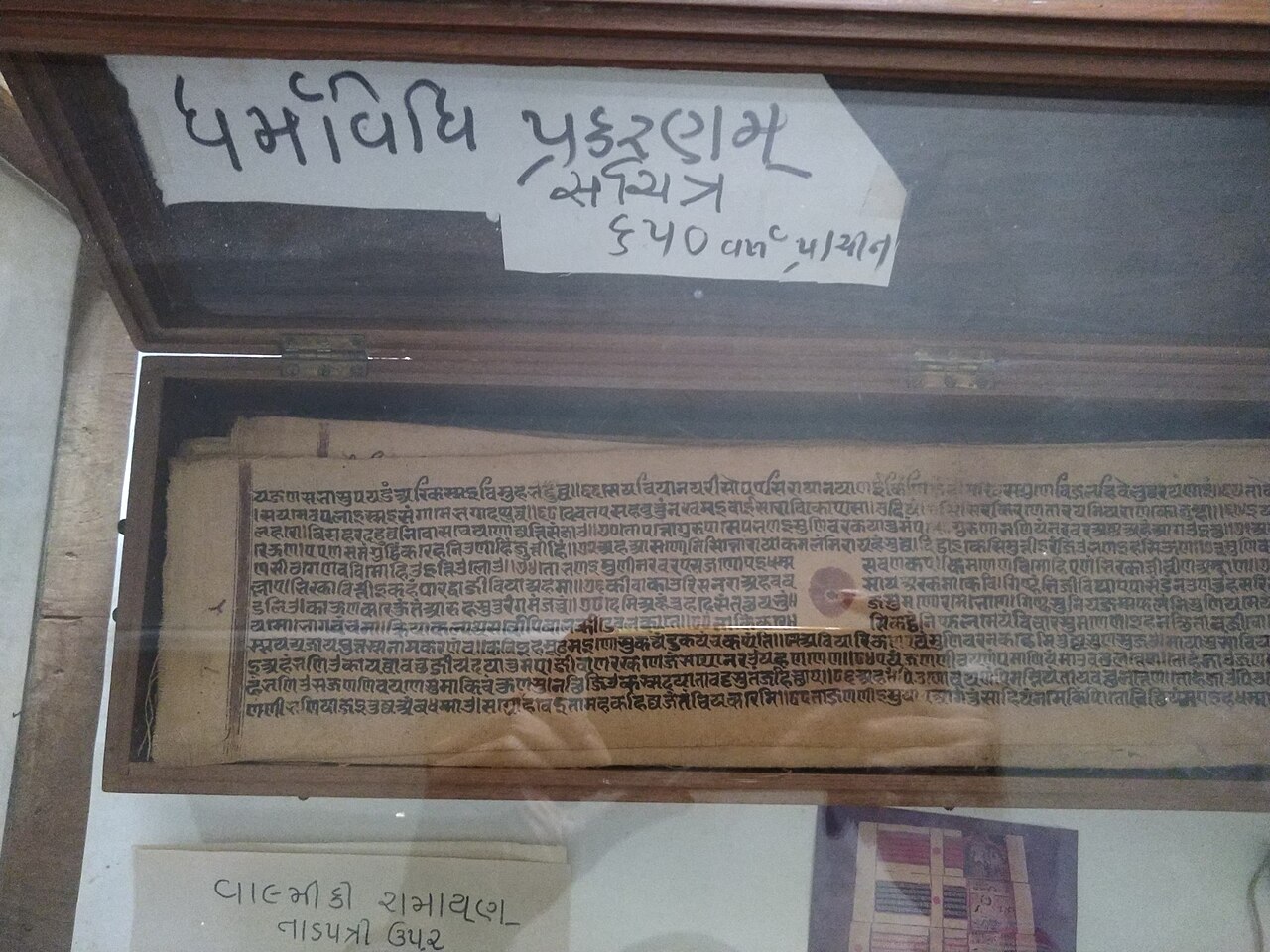 An early manuscript preserved in a wooden display case, close documentary shot, soft archival lighting
